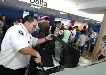 f: Federal Transportation Secuity Administration (TSA) security screeners inspect luggage with a special reactive wand which can detect explosive material at a check-in counter at Los Angeles International Airport, 29 August 2003 in Los Angeles. TSA security screens are gearing up for the nearly 700,000 passengers are expected at the airport over the upcoming Labor Day weekend.