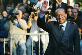 Italian Prime Minister Silvio Berlusconi waves to the journalists after he met with Rome's chief Rabbi Riccardo Di Segni, 17 September 2003 in front of the synagogue in Rome. Berlusconi apologised to the country's Jewish community for his claim that Fascist World War II leader Mussolini never killed anyone, a community spokesman said today