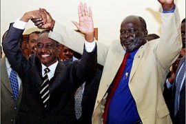 Sudanese vice-president Ali Osman Taha (L) and Sudan People Liberation Army (SPLA) leader John Garang celebrate after signing an agreement on security issues, seen as a key step in reaching a comprehensive accord to end Africa's longest war, in the Kenyan town of Naivasha, 90 km west of Nairobi, 25 September 2003. AFP PHOTO/SIMON MAINA