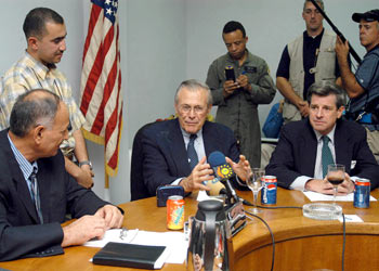 r: U.S. Secretary of Defence Donald Rumsfeld (C) gestures as he talks flanked by Paul Bremer (R), top U.S. civilian administrator in Iraq during a meeting with the Mayor of Mosul Ghanam Al-Basso (L) during his visit to the northern Iraqi city of Mosul September 5, 2003. Standing between the Rumsfeld and mayor is an unidentified interpreter.