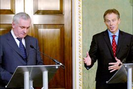 Britain's Prime Minister Tony Blair gestures as he addresses a joint news conference with his Irish counterpart Bertie Ahern (L) at Hillsborough Castle in Belfast October 21, 2003. Blair said on Tuesday that he was convinced the Irish Republican Army (IRA) had agreed to end paramilitary violence in line with the Northern Irelend peace deal. REUTERS/Paul Mcerlane