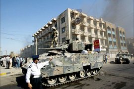 F_US soldiers and Iraqi police secure the area during a blaze at the Al-Madar Hotel 06 October 2003 in Baghdad. The fire, electrical in nature, was caused by accident. AFP PHOTO/Ramzi HAIDAR