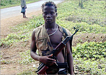 A 16-year-old Liberian rebel fighter named John mans a check point outside the rebel-held port town of Buchanan, November 23, 2003. United Nations peacekeepers in Liberia plan to launch a disarmament exercise on December 1, hoping to persuade an estimated 40,000 fighters in the West African country to lay down their guns. REUTERS Matthew Green TO MATCH FEATURE LIBERIA-DISARMAMENT