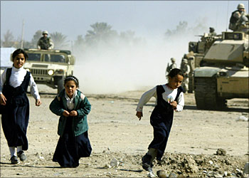 Iraqi schoolgirls flee an approaching US army patrol in the Baghdad suburb of Abu Gharib 05 November 2003. US-led troops and civilians seen as cooperating with them are facing increasingly daring attacks, notably in the very seat of the occupation forces in Baghdad.
