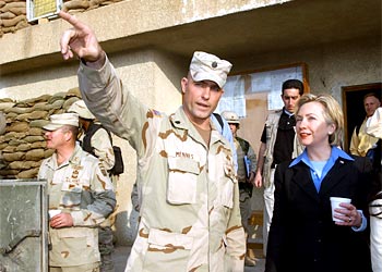 f: Former US first lady, Senator Hillary Rodham Clinton (R), listens Lt. Col. Brian Mennes during a tour of the barracks of the 2nd battalion, 2nd Airborne Division, in Baghdad