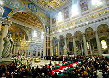 Sun shines down on 19 Italian coffins during a state funeral service at the Saint Paul's Basilica outside-the-walls in Rome November 18, 2003. Thousands took to the streets in a national day of mourning as the bodies of the 17 soldiers and two civilians, who were killed in a deadly attack on a military base in Iraq last week, were blessed. REUTERS/Alessandro Bianchi