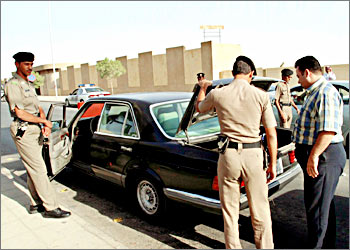 Saudi Arabian policemen check a car in Riyadh November 11, 2003. Saudi Arabia has detained suspects in the devastating suicide bomb attack on a housing complex in Riyadh after vowing to strike back with an "iron fist". REUTERS/ Sultan Al Fahed