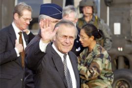 US Defense Secretary Donald Rumsfeld (3rd L) waves to journalists upon his arrival at the US Forces' Yokota Air Base in Tokyo 15 November 2003. Rumsfeld arrived here by UA-60 helicopter from Yokosuka Naval Base