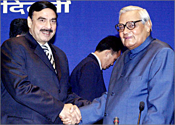 Indian Prime Minister Atal Behari Vajpayee (R) shakes hands with Pakistan's Information Minister Sheikh Rashid Ahmed (L) at the inaguration of the Information Ministers conference for South Asian Association of Regional Cooperation (SAARC) countries in New Delhi, 11 November 2003. Pakistan's Information Minister Sheikh Rashid Ahmed, 11 November formally invited Indian Prime Minister Atal Bihari Vajpayee for the SAARC Summit to be held in Islamabad in January 2004 and called for the resolution of ''basic issues'' between the two countries. AFP PHOTO/RAVEENDRAN