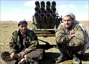This picture dated 17 November 2003 shows two Afghan militiamen posing in front of a rocket launcher during a disarmament cermony in Gardez, the capital of Paktia province where about 600 Afghan militiamen handed over their guns in the latest phase of an ambitious disarmament program. Reining in powerful warlords and disarming some 100,000 militiamen are among the major challenges facing Afghan President Hamid Karzai as he attempts to extend his authority to the provinces.