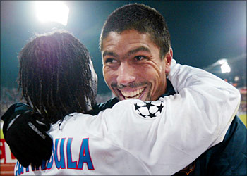 Olympique Lyon's Brazilian forward Giovane Elber hugs teammate Peguy Luyindula of France after their defeating Bayern Munich, 05 November 2003 at the Munich Olympic Stadium, during their group A Champions League match. Lyon won 2-