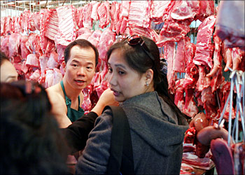 A butcher serves customers in a market in Hong Kong whilst the government here monitors a suspected case of mad cow disease in the US, 24 December 2003. US Agricultural Secretary Ann Veneman said a cow from Washington state had tested positive for the bovine disease which if contaminated meat is consumed by humans can cause a varient of Creutzfeld-Jacob disease, which has claimed more than 140 lives in Europe.