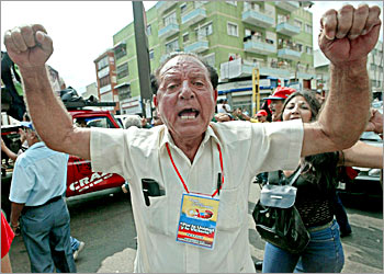 Supporters of Venezuelan President Hugo Chavez cry slogans in front of a polling station where the opposers sign up the referendum to oust him, 30 November, 2003 in Caracas. The Venezuelan opposition on Sunday claimed huge public support for its new drive to oust President Chavez whose government sealed part of the border with Colombia claiming illegal immigrants were involved in election fraud. The opposition has four days, ending Monday, to collect 2.4 million signatures for a referendum seeking the recall of the populist president, who has already been the target of a coup attempt and a general strike during his controversial term. AFP PHOTO/Juan BARRETO