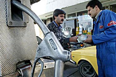 An Iranian driver pays for gas at a Tehran gas station 07 December 2003. With fuel consumption up and the government