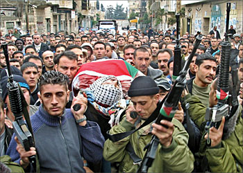 F_Palestinian gunmen carry the body of Amjad Sadi, 28, during his funeral in the West Bank town of Jenin 03 December 2003. Sadi, a member of the Al-Aqsa Martyrs Brigades which is a largely autonomous offshoot of Palestinian leader Yasser Arafat's mainstream Fatah movement, was killed during an exchange of fire with the Israeli troops, who had moved into both the town of Jenin and the nearby Palestinian refugee camp, seeking to arrest activists. AFP PHOTO/ SAIF DAHLAH