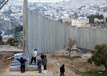 F_Workers lay a concrete block during the construction of the Israeli controversial securiy fence in the West Bank city of Abu Dis in the outskirts of Jerusalem 26 January 2004. Israel is to submit to the International Court of Justice (ICJ) at the end of the week written arguments in defence of its controversial West Bank separation barrier, a senior foreign ministry official said. AFP PHOTO/Atta HUSSEIN