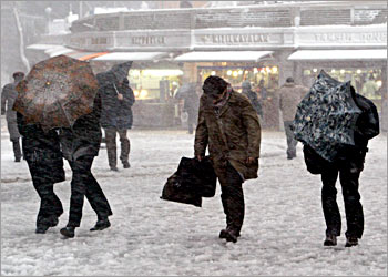 People try to walk in a heavy snowstorm in Taksim square area in Istanbul, Turkey.AFP PHOTO/Mustafa Ozer