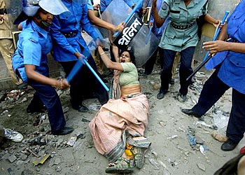 f: Bangladeshi policemen use their batons to hit a female activist of country's main opposition Awami League (AL) party during a day-long nationwide general strike in Dhaka,