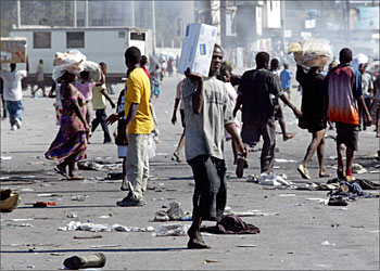 F_Looters carry boxes from inside the port 27 February 2004 in Port-au-Prince. Deadly violence, looting and chaos broke out 27 Fewbruary 2004 in Port-au-Prince amid fears that the rebels who already seized most of the country were set to storm this crisis-wracked Caribbean capital. AFP PHOTO/JAIME RAZURI