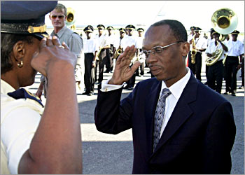 (FILES) Haitian President Jean Bertrand Aristide is saluted by a police officer prior to his departure 12 January 2004 from Port-au-Prince to Mexico where he will attend the Summit of the Americas. Aristide has left power in Haiti, the French foreign ministry said 29 February 2004. AFP PHOTO Thony BELIZAIRE