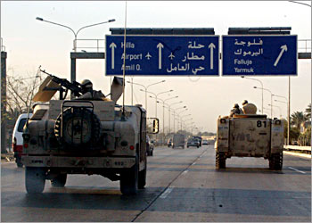 US troops in armored vehicles patrol the highway that links Baghdad with the flashpoint city of Fallujah 15 March 2004. The body of a policeman from Fallujah, who disappeared three days ago, was discovered yesterday riddled with bullet holes, a police officer in the rebellious Sunni Muslim city said. The police in Fallujah, 50 kms (30 miles) west of Baghdad, are the target of many guerrilla attacks because of their perceived cooperation with the US-led occupying forces. AFP PHOTO/Karim SAHIB