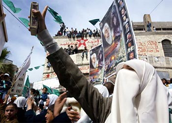f: A Palestinian woman supporter of Hamas holds up the Muslim holy Koran during a demonstration in the West Bank city of Nablus,