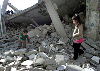 Palestinian children walk on the rubble of the destroyed house of Palestinian suicide bomber Muhammad Ahmed Shoaani who explodes himself in Jerusalem on 29 March 2002 killing 11 Israelis, in the Dahaisha refugee camp, south of the West Bank town of Bethlehem, 21 March 2004. The Israeli army destroyed two houses belong to Palestinian suicides bombers in the camp