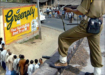Indian security force personnel guard a line of voters as they queue to cast their votes in India's general election at a polling station in Barh, some 130 kms south of Patna, 20 April 2004. India has begun the world's largest election with the ruling Hindu nationalists hoping soaring economic growth will win them a new mandate from the 670 million eligible voters. Voters turned out in large numbers in many of the 140 constituencies spread over 13 states and three federal territories that have voted the first of five dates in the marathon election whose results will be announced 13 May.