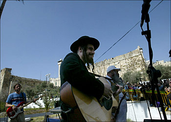 afp - A member of the traditional band "the Solomons" performs 08 April 2004 in front of the Tomb of the Patriarchs in the divided West Bank city of Hebron. Some 10,000 Israelis took over the streets of the one of the largest Palestinian towns in a massive show of support for Jewish settlers during the Passover holiday. AFP PHOTO/MARCO LONGARI