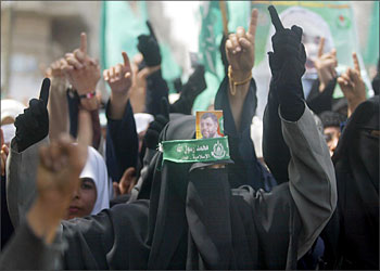 F_Palestinian female supporters of the Islamic Resistance Movement Hamas shout anti-Israel slogans during the funeral procession of Hamas leader Abdelaziz Rantissi (portrait) in Gaza City 18 April 2004. Hamas threatened a "volcano of revenge" against Israel as it bid farewell to Rantissi, whose anonymous successor was kept under wraps for fear he may meet the same fate. Rantissi was killed late last night when an Israeli helicopter fired rockets into his car in Gaza City, less than a month after the movement's spiritual leader Sheikh Ahmed Yassin was killed in a similar attack. Arabic writing on Hamas bandana on woman's head reads: "Mohammed is the Prophet of God". AFP PHOTO/Mahmud HAMS