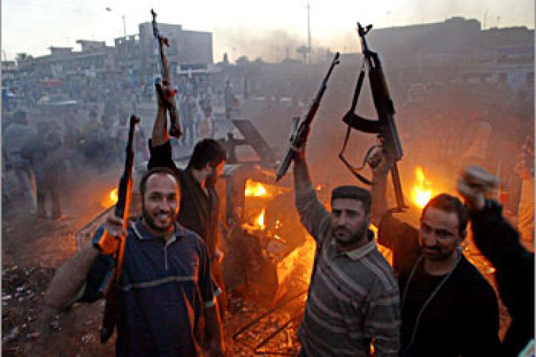 Muslim Shiite members of Shiite radical leader Moqtada al-Sadr Army of Mehdi militia celebrate near a burning US Humvee in Baghdads al-Sadr City district late 04 April 2004. The radical cleric , whose militiamen are clashing with US-led coalition troops in Iraq, told his supporters to terrorize the enemy as demonstrations were no longer any use. Clashes today with coalition troops have left some 25 dead Iraqis and hundreds of injured. AFP PHOTO/AHMAD AL-RUBAYE
