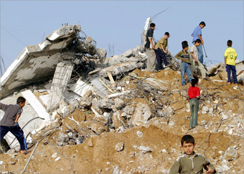 Palestinians walk amid the rubble of a destroyed house in Deir al-Balah in the Gaza Strip 27 May 2004. Since August 2002, the Israeli army has destroyed hundreds of family homes in the West Bank and the Gaza Strip belonging to Palestinians accused of involvement in anti-Israeli attacks, sparking accusations from human rights watchdogs of collective punishment. The Israeli army has also carried out a mass program of demolition in Rafah in the southern Gaza Strip, the scene of a week-long raid that ended 24 May, claiming the lives of more than 40 Palestinians. AFP PHOTO/MOHAMMED ABED