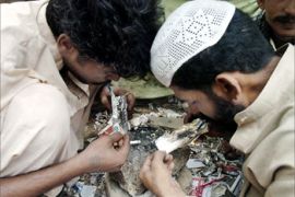 Two Pakistani drug addicts inhale 'brown sugar' in a Karachi slum, 25 June 2004. Pakistan is a major transit and consumer country for opiates from neighbouring Afghanistan, the world's largest producer of opium, as a result of the high levels of opium production in the region over the past two decades, Pakistan now has one of the highest addiction rates in the world. The world nations will observe International Day against drug abuse on 26 June 2004