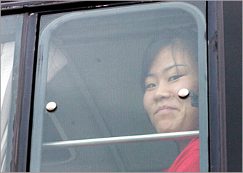 A North Korean defector smiles through a window on a bus after arriving in South Korea, in Sungnam, about 24 km (15 miles) south of Seoul, July 27, 2004. A special chartered plane believed to be carrying more than 200 North Korean refugees arrived in South Korea on Tuesday, bringing them from temporary asylum in an unidentified Southeast Asian country. KOREA OUT NO ARCHIVE NO SALES REUTERS/Hong In-ki/The Hankook Ilbo