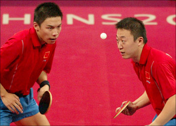 Chen Qi (L) and Ma Lin from China concentrate on the ball on their way to winning the gold medal in the men's doubles table tennis at the Athens 2004 Olympic Games August 21, 2004. Chen Qi and Ma Lin defeated Ko Lai Chak and Li Ching of Hong Kong 4-2 to win the gold. REUTERS/Mike Hutchings