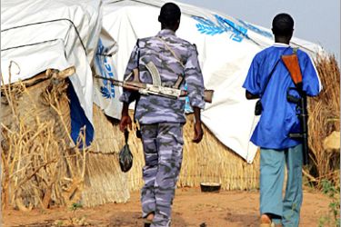Sudanese policemen patrol the Internally Displaced Persons (IDP) camp of Krinding on the outskirts of the western town