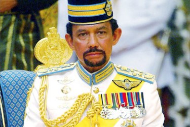 Brunei's King Hassanal Bolkiah sits during his son's wedding ceremony in Bandar Seri Begawan in this September 9, 2004 file