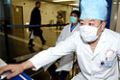 A masked Chinese medical worker controls a thermal-imaging thermometer to monitor travellers temperatures at Beijing Capital International Airport January 6, 2004