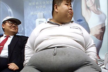 r_Guan Chen (R), 24, sits after being weighed-in at a