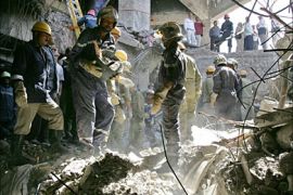 f_Israeli and Egyptian rescuers work in a pit digging for victims