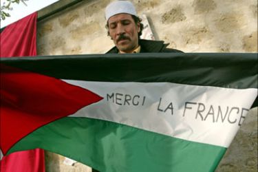 f_A man displays a Palestinian flag reading "Thank you