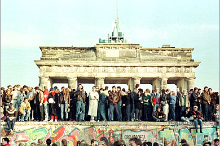 REUTERS - West Berlin citizens continue their vigil atop the Berlin Wall in front of the Brandeburg Gate in this November 10, 1989 file