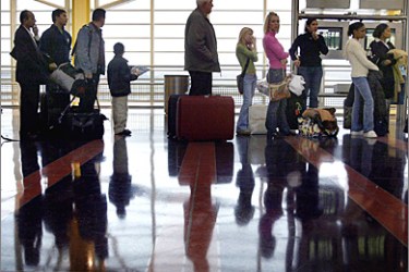 AFP - During the busiest travel day of the year, passengers stand in line 23 December, 2004 at Reagan National Airport in