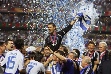 Greek team members hold the cup and celebrate, 04 July 2004
