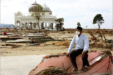 REUTERS/An Acehnese man who lost his family in last week's massive tsunami sits among the ruins of his home near Banda Aceh,