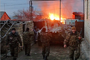 AFP - Russian special forces soldiers stand behind an APC as they storm a house near the Dagestan capital Makhachkala