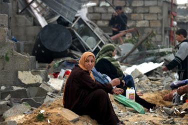 Palestinian women sit outside their house after it was destroyed by Israeli troops at the Khan Younis refugee camp southern Gaza Strip, January 2, 2005.