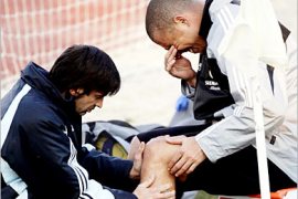 REUTERS/ Real Madrid's Brazilian Ronaldo (R) grimaces while having his knee checked after stopping running during a training