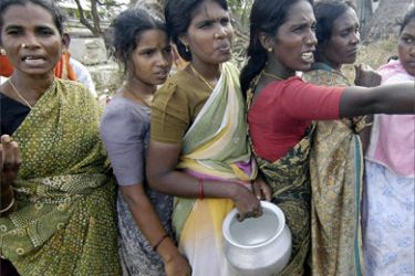 Indian women of the Akkrapattai fishing colony who were displaced by the tsunami, queue for rice at a relief camp in Nagapattinam some 350 kms south of Madras, 01 January 2005