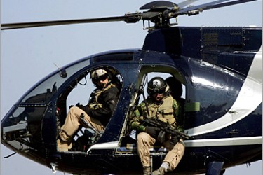 AFP - Members of the US blackwater security firm scan Baghdad city centre from their helicopter 05 February 2005. Insurgents